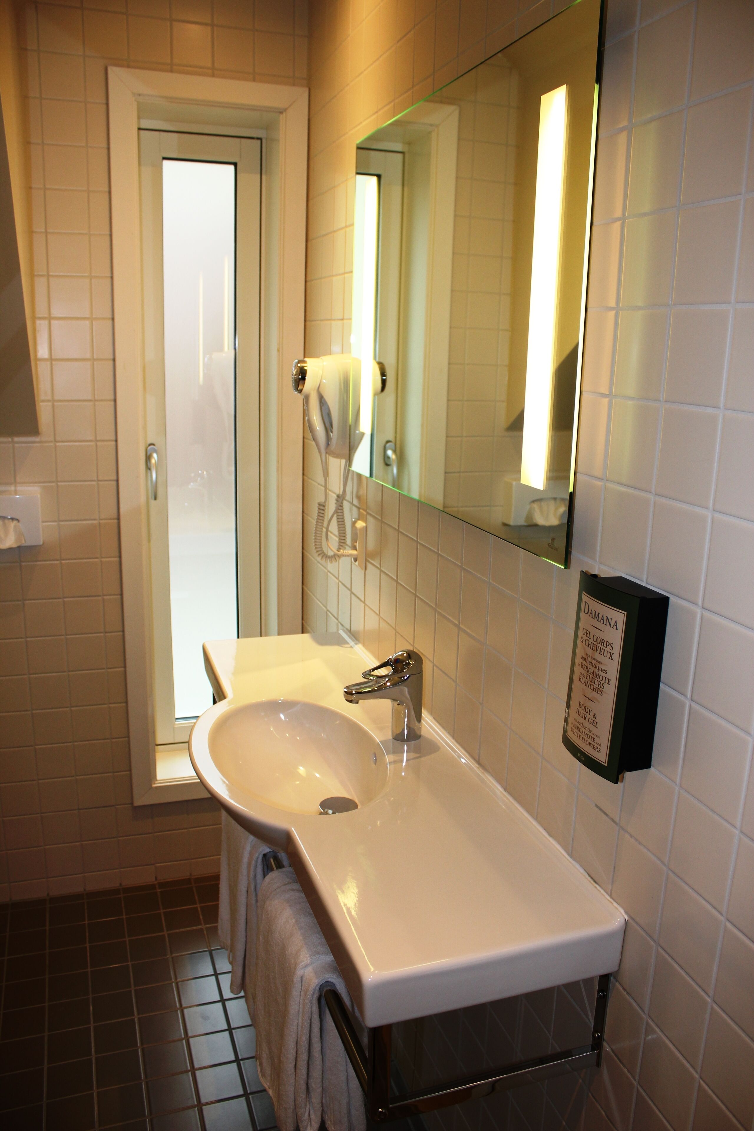A bathroom with a white sink, a mirror, and a glass shower door.