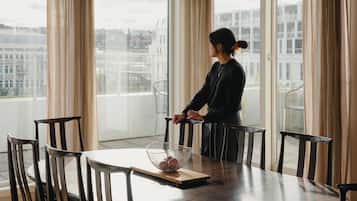 A dining area with a table, chairs, and a window with curtains.