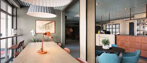 A modern conference room with a long table, chairs, and a bar area.