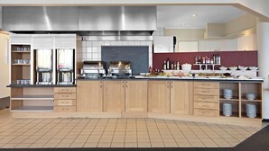 Uma cozinha moderna com armários de madeira, eletrodomésticos de aço inoxidável e painel de azulejos.