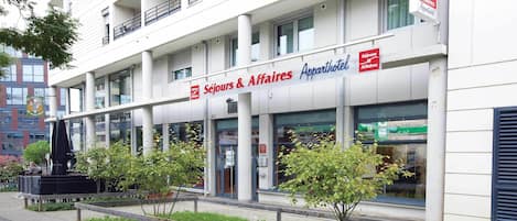 A building with a sign reading "Séjours & Affaires Appartements" indicating it houses both short-term stays and office apartments.