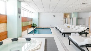 Un spa moderno con piscina, sillas de descanso y jacuzzi.
