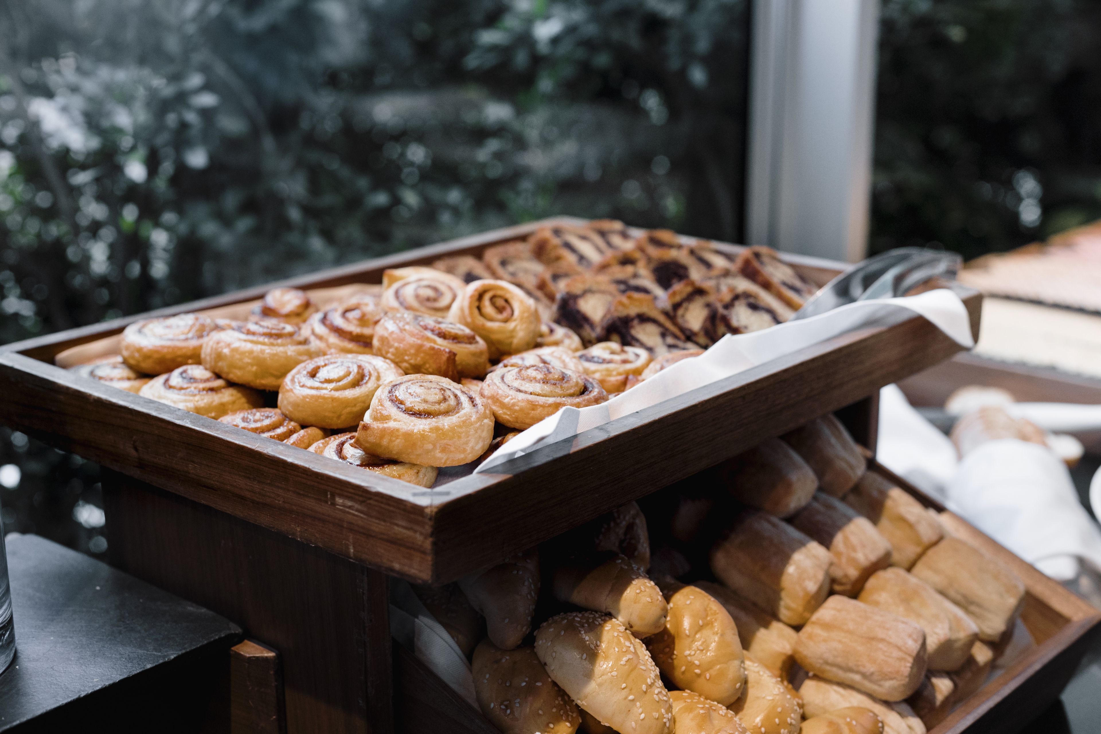 Een schaal met diverse gebakjes, waaronder kaneelbroodjes en sesambollusjes.