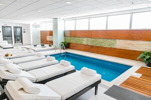 Una piscina techada, sillones reclinables de piscina