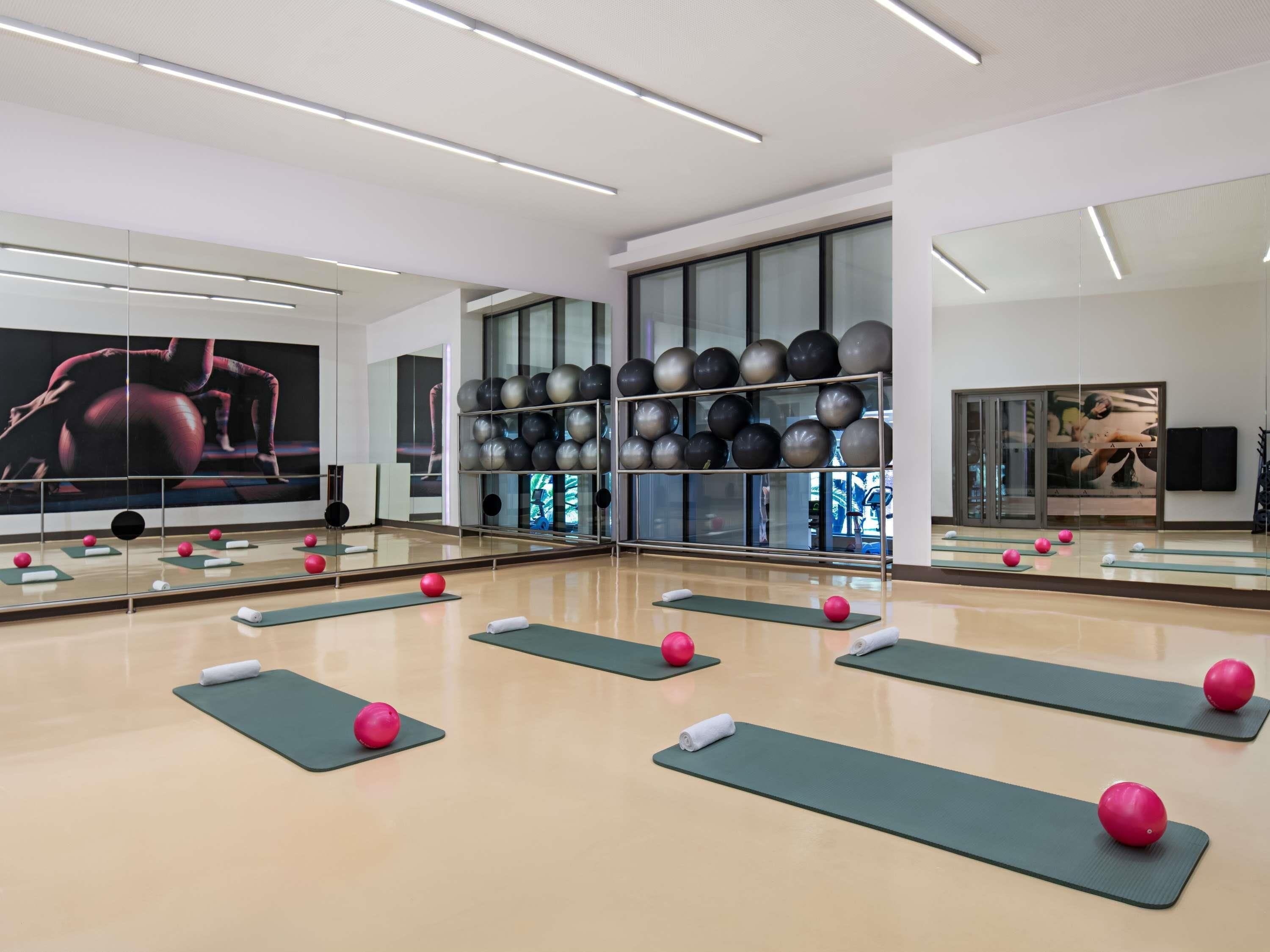 A gym with exercise balls, mirrors, and yoga mats.