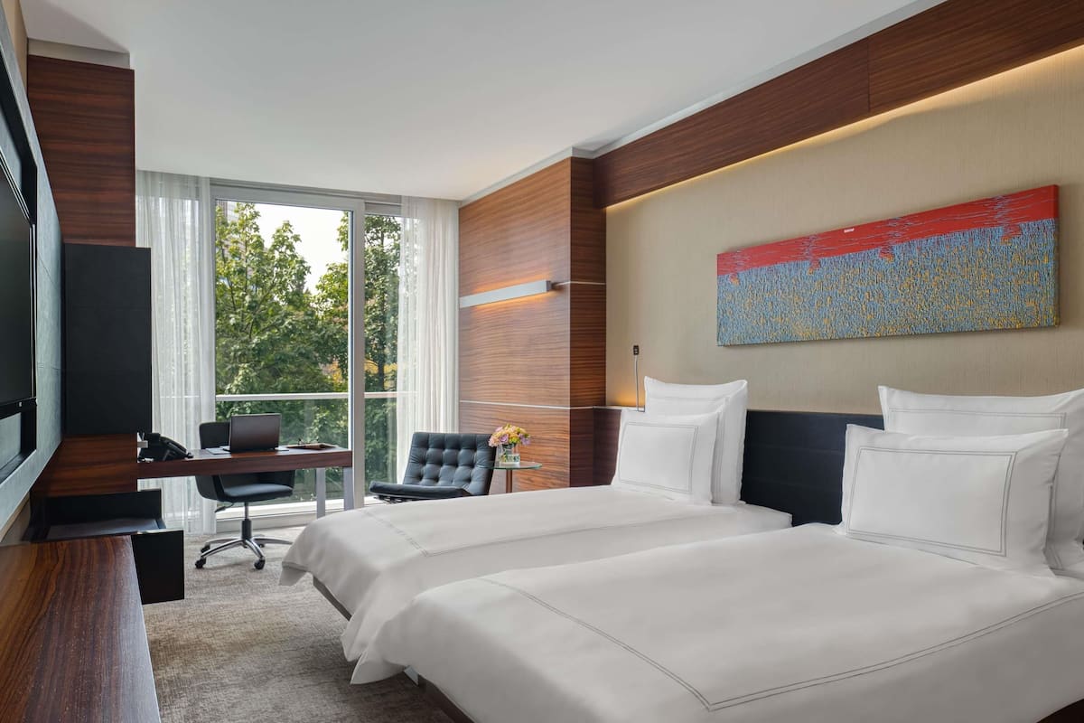 Une chambre d’hôtel avec un grand lit, un bureau, une chaise et un téléviseur.
