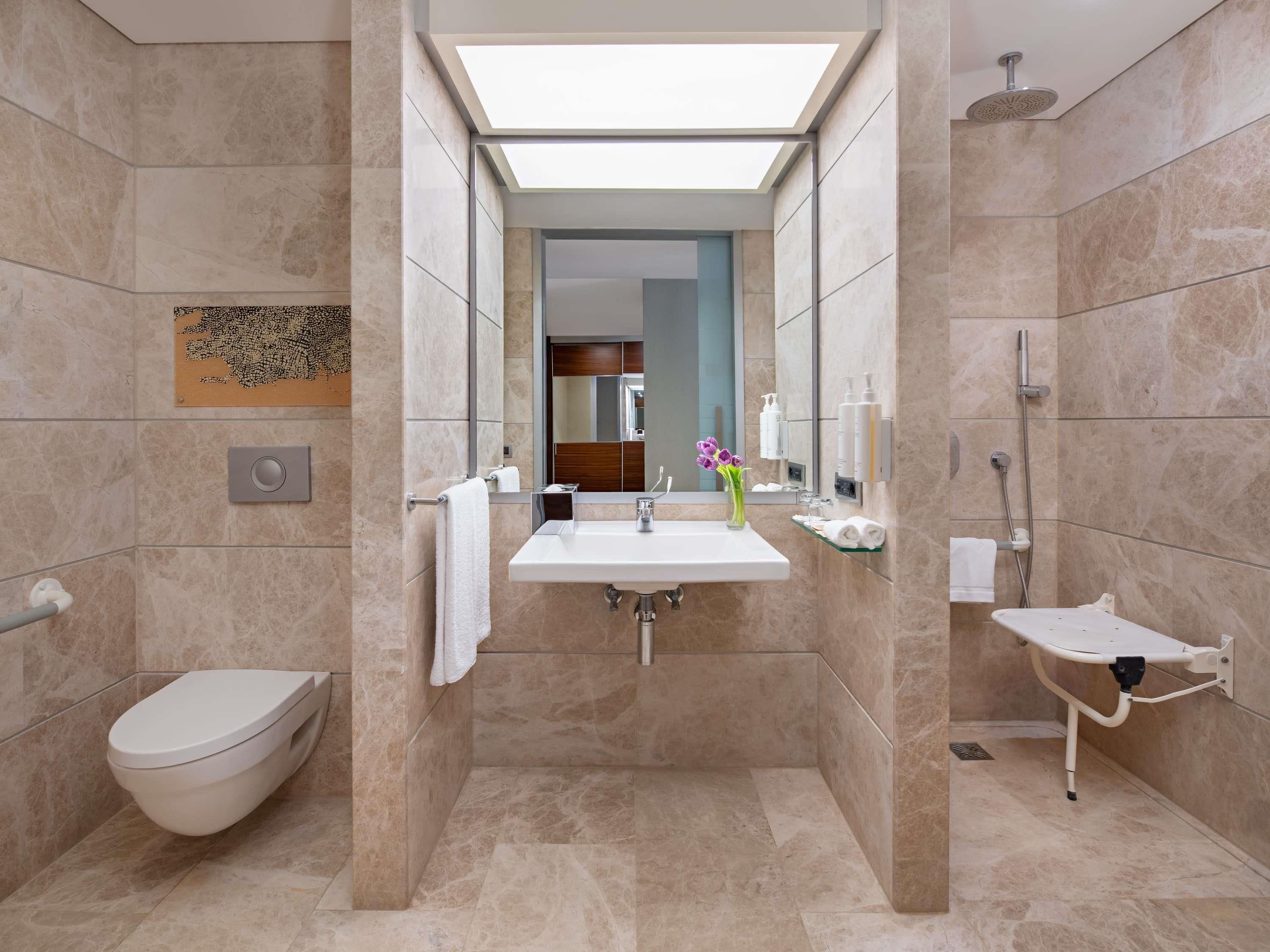 A modern bathroom with a toilet, sink, and shower.