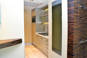 Una cocina compacta con microondas, lavamanos y electrodomésticos de acero inoxidable.