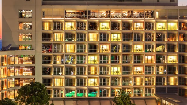 Un hotel dalla facciata moderna, con diversi piani e una zona piscina.