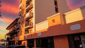 Un hotel llamado 'Hotel Plaza Independencia' con un estilo arquitectónico moderno, que cuenta con balcones y un cartel llamativo.