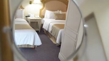 A circular view of a hotel room with two beds, a nightstand, and a lamp.