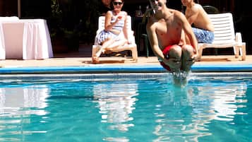 Una piscina al aire libre, sillones reclinables de piscina