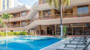 A multi-story hotel with a swimming pool, outdoor seating, and balconies. - Best Western Plus Plaza Florida & Tower (Irapuato)