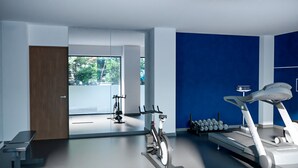 A modern gym with exercise equipment, a large window, and a blue accent wall. - Holiday Inn Express Ciudad De Mexico Condesa by IHG (Mexico City)