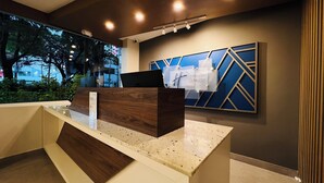 A reception desk with a wooden finish, a blue geometric wall art piece, and a sign for 'Holiday Inn Express.' - Holiday Inn Express Ciudad De Mexico Condesa by IHG (Mexico City)