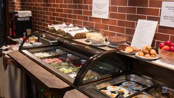 A buffet with various food options, including eggs, salads, and fruits.