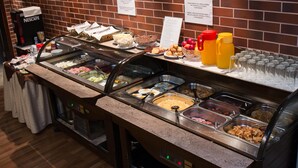 A buffet with various food options and a Nescafé coffee machine.