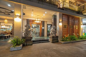 A hotel entrance with a reception desk, a staircase, and a balcony with railings. - Nirmala Heritage Hotel (Jimbaran)