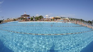 Una piscina al aire libre de temporada, sombrillas