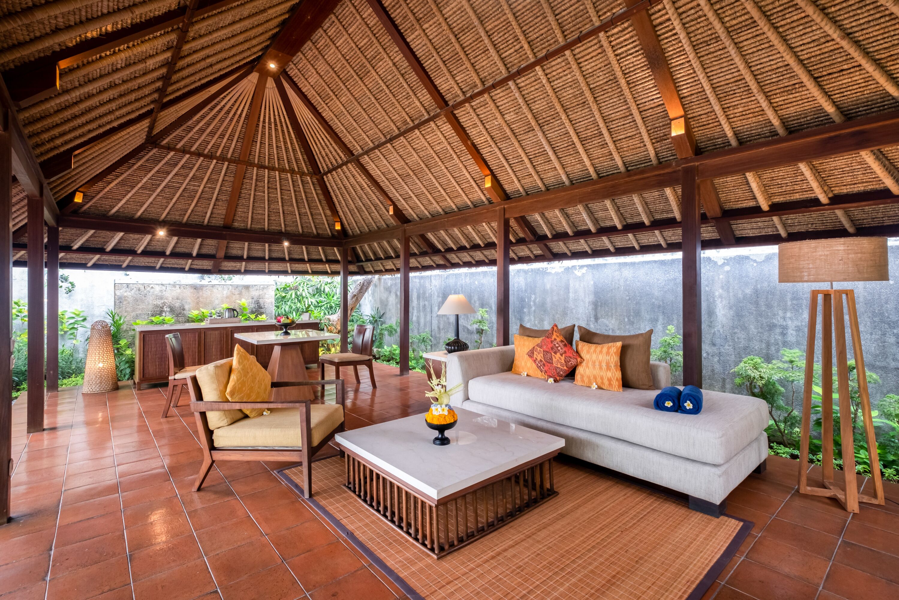A spacious indoor area with a high ceiling, a sofa, a coffee table, and a dining table.