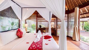 A bedroom with a canopy bed, a desk, and a view of greenery. - Mayaloka Villas Seminyak (Keroboken Kelod)