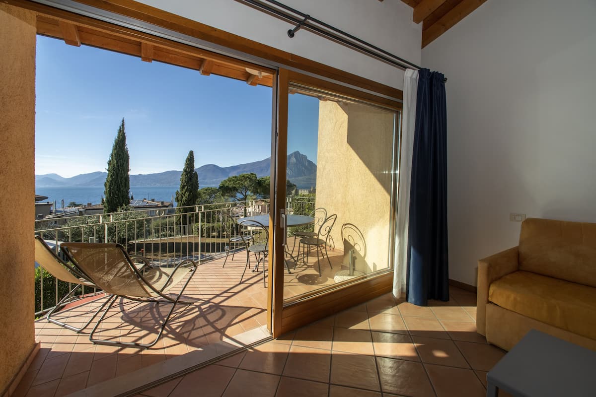 A balcony with a chair, a table, and a sofa.