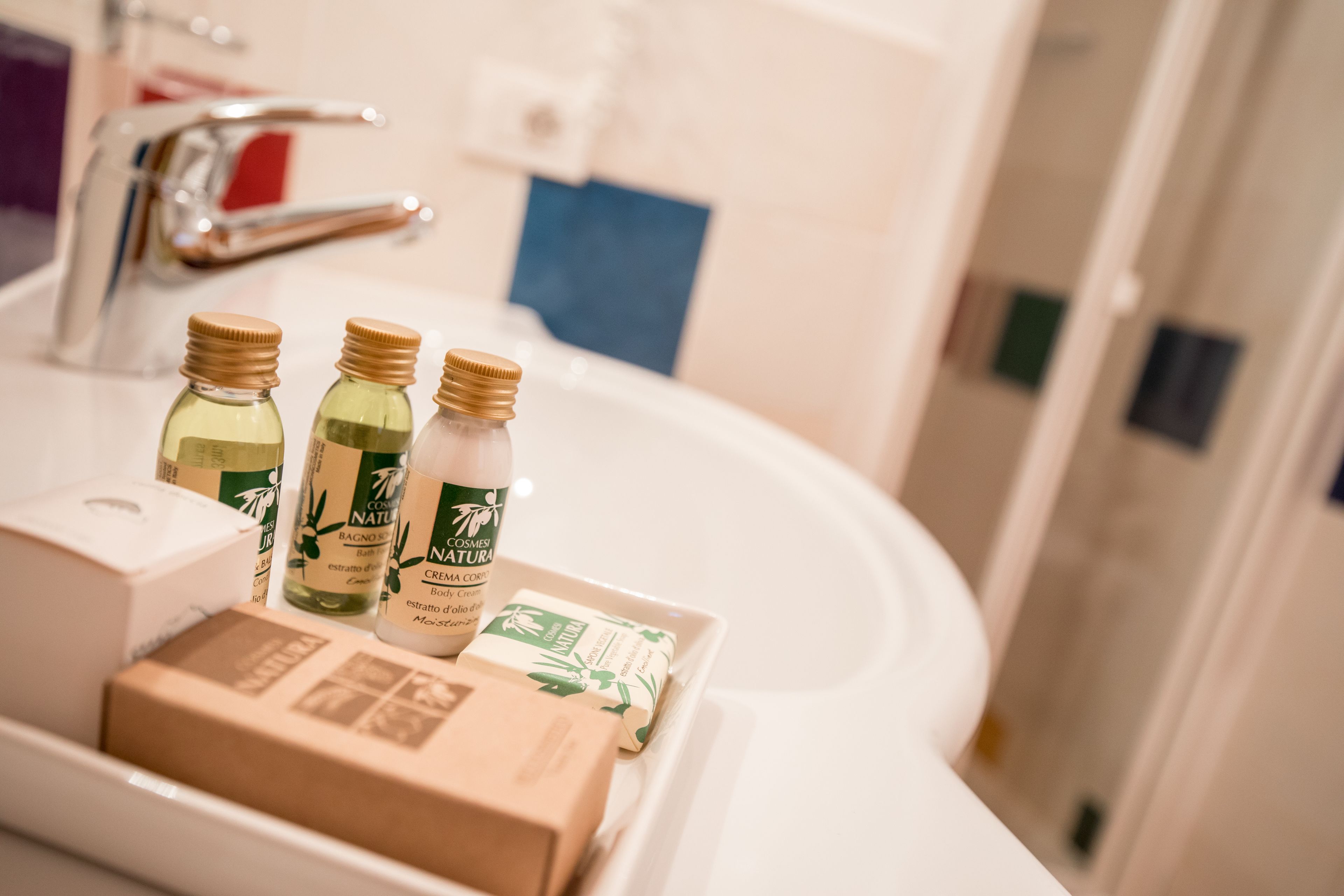 Un lavabo de salle de bain avec trois flacons de lotion et une boîte de savon.