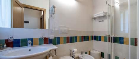 Une salle de bain équipée d’un lavabo, de toilettes, d’un bidet et d’une douche.