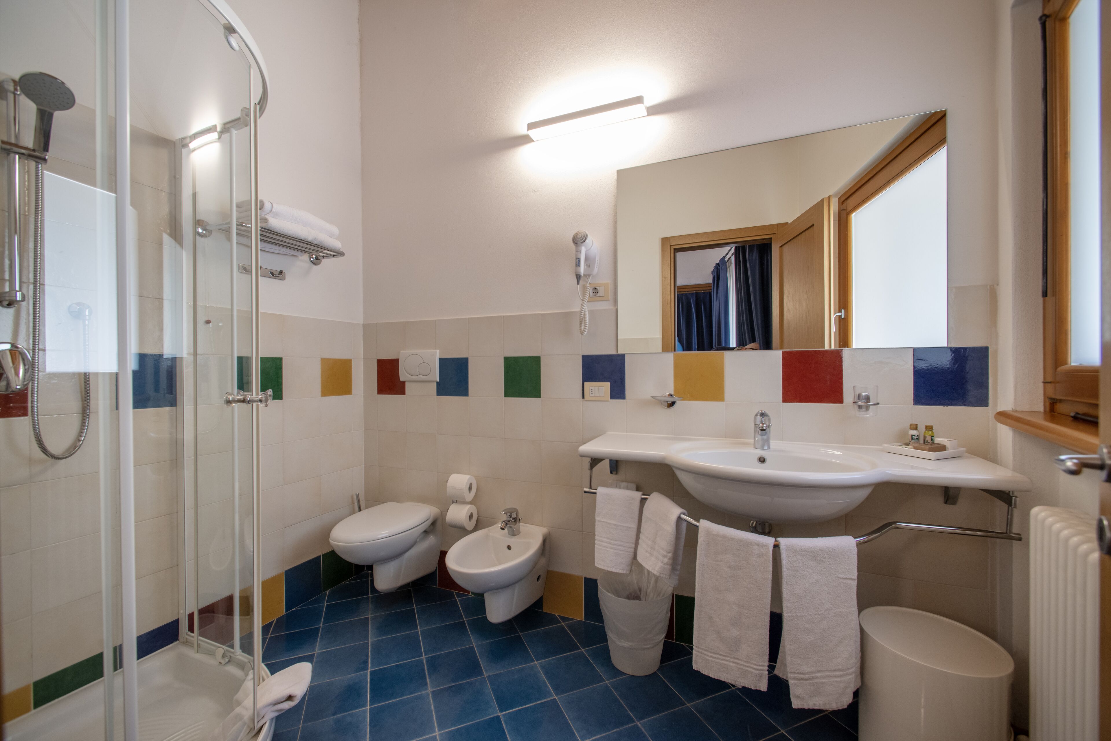 Een badkamer met douche, toilet, bidet en wastafel.
