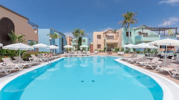 Alberca al aire libre, sombrillas en la alberca y camastros