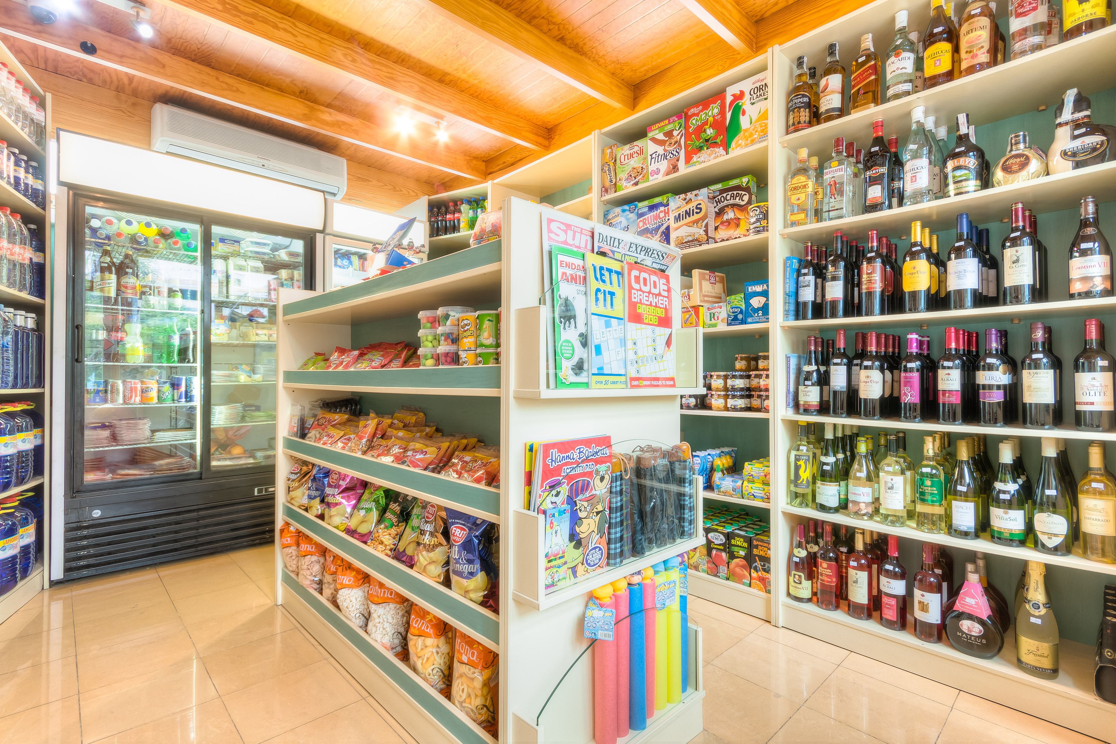 A store with shelves stocked with snacks, beverages, and magazines.