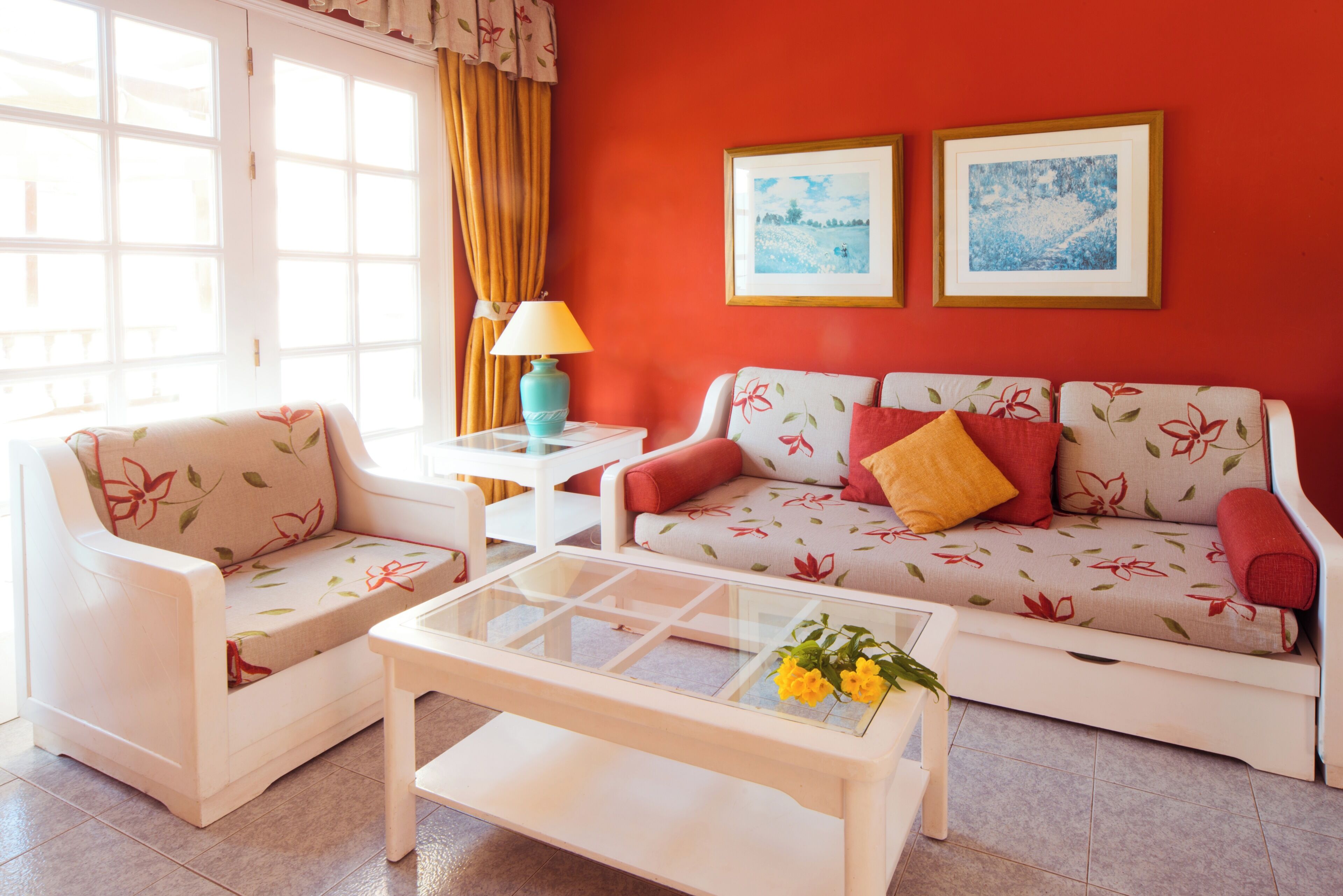 A living room with a sofa, two armchairs, a coffee table, and two framed pictures on the wall.