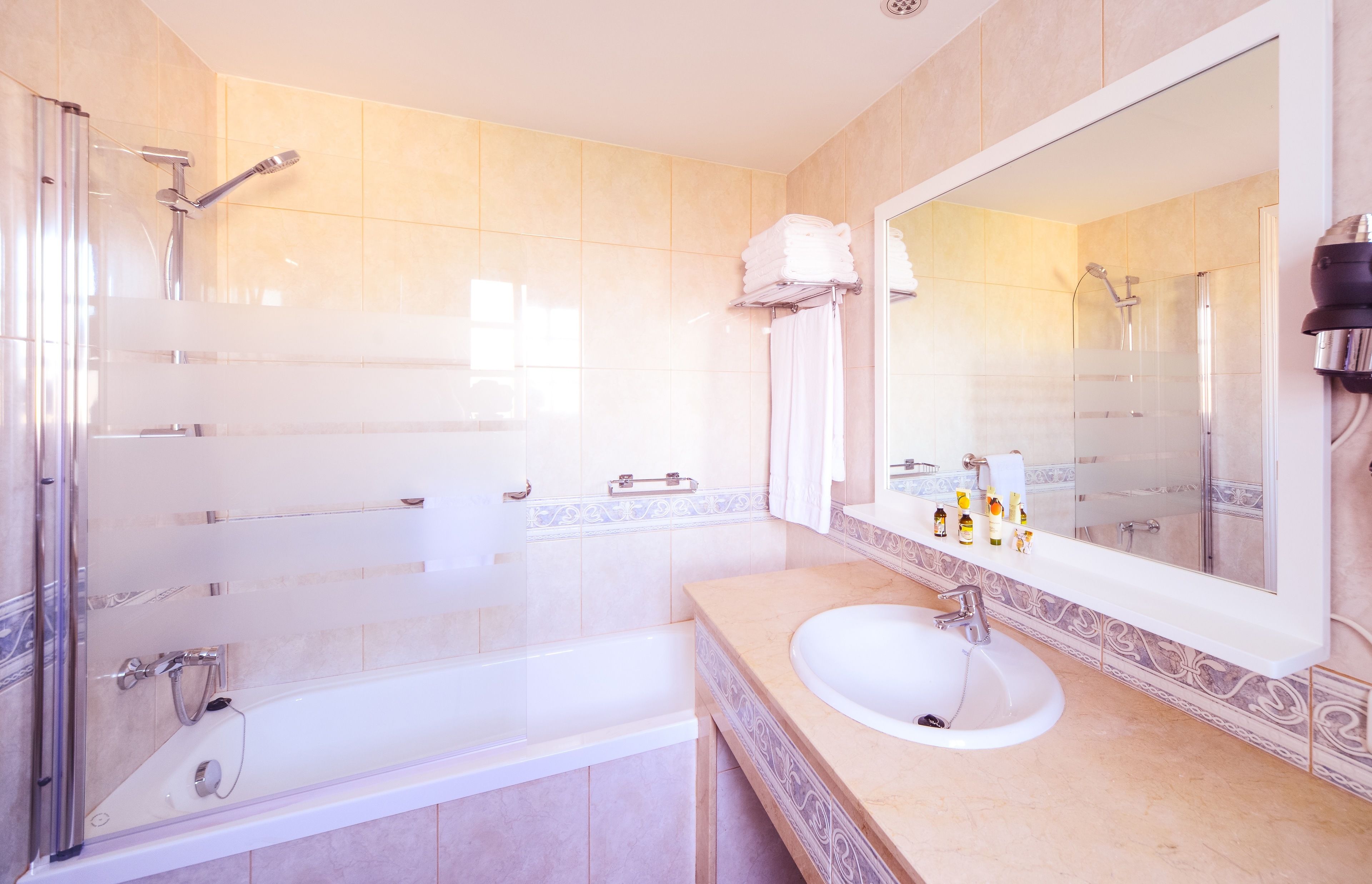 Un baño moderno con una bañera, un lavabo y un espejo grande.