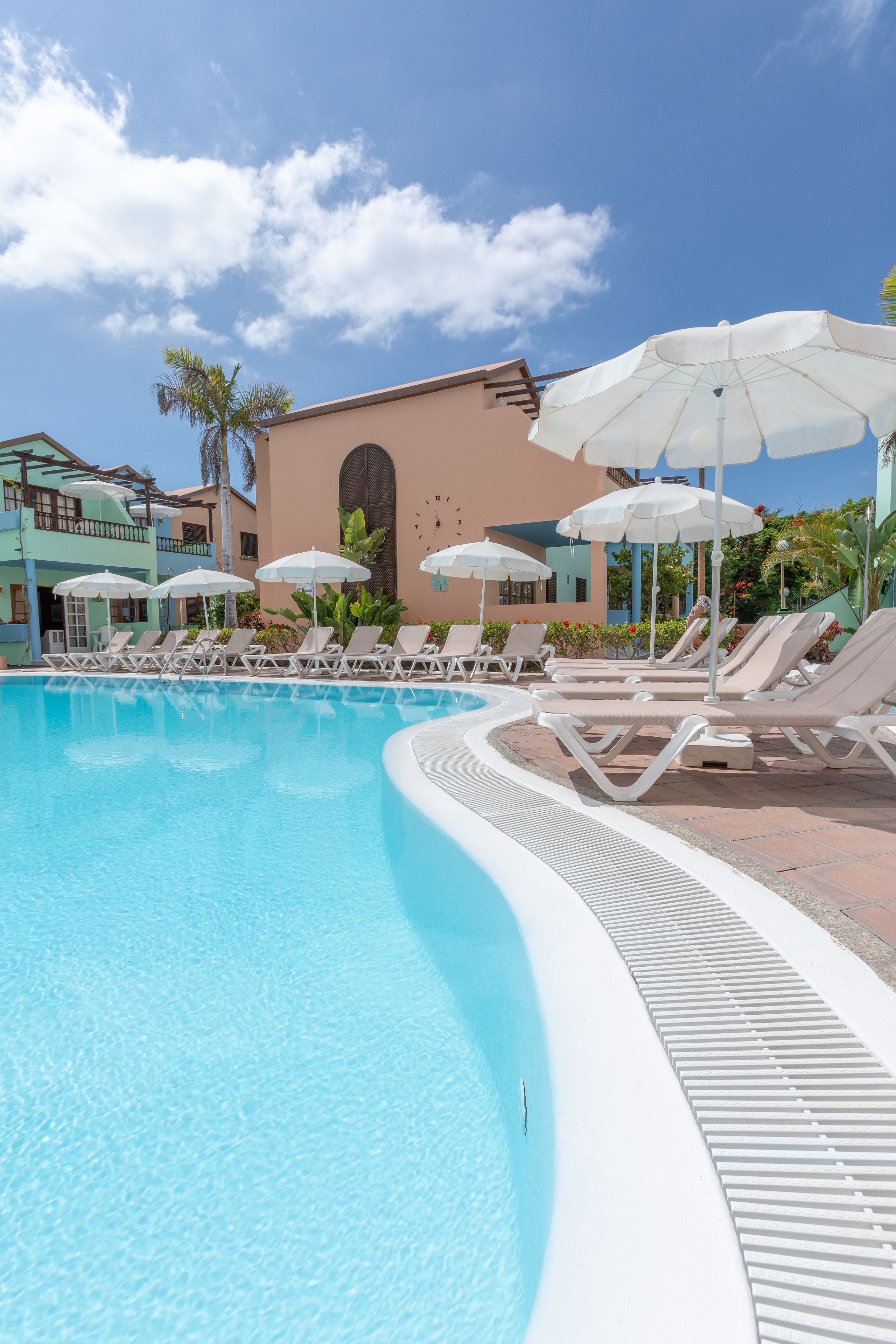 Een buitenzwembad, parasols voor strand/zwembad