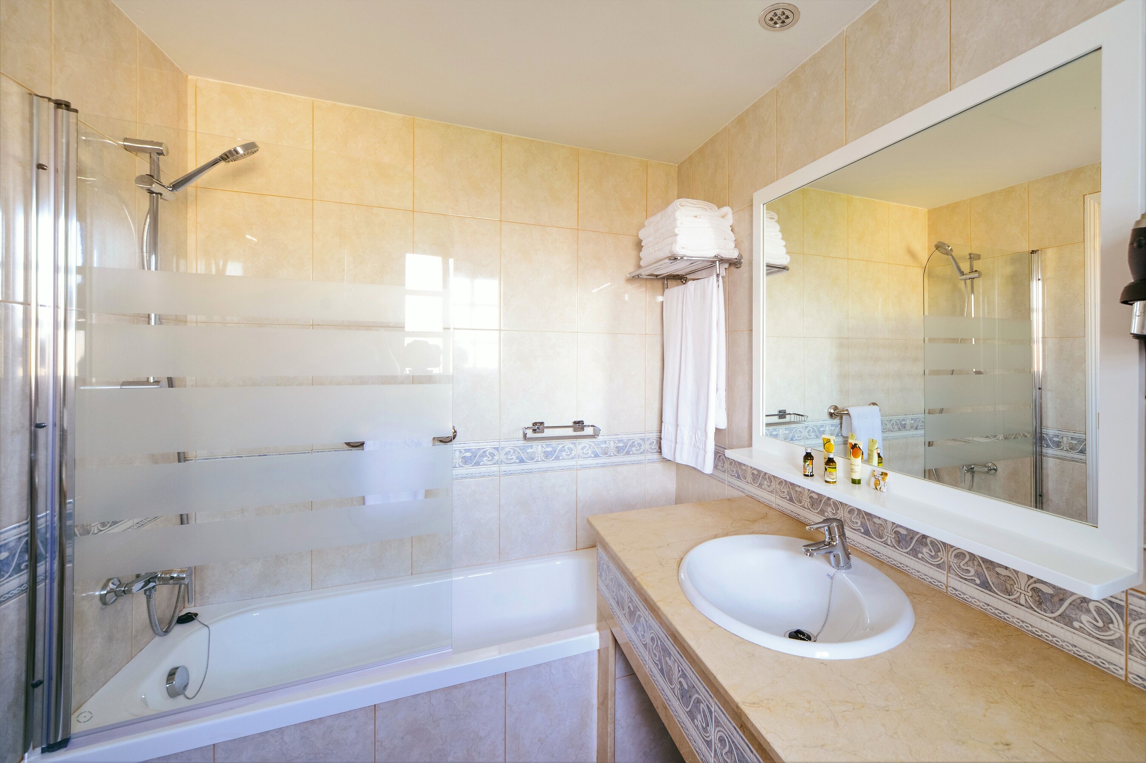 Une salle de bain moderne dotée d’une douche à parois de verre, d’une baignoire, d’un lavabo et d’un grand miroir.