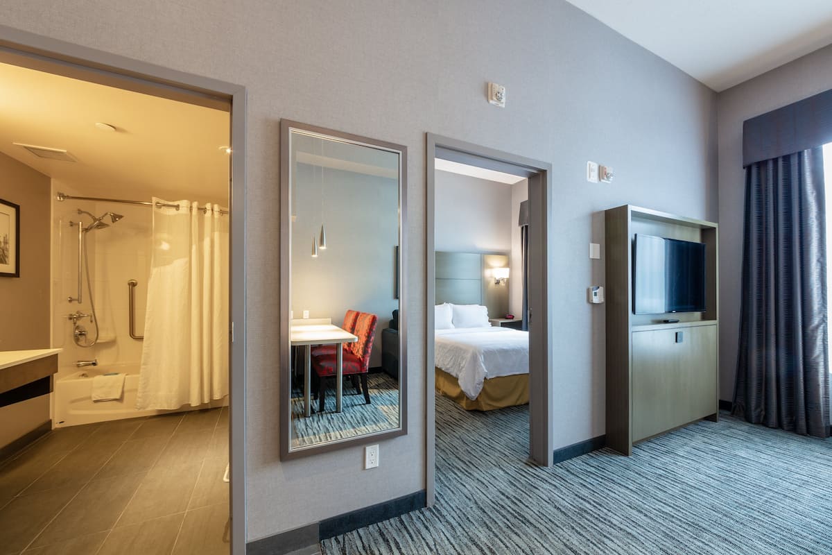 Une chambre d’hôtel équipée d’une douche, d’un lit, d’un bureau et d’une télévision.