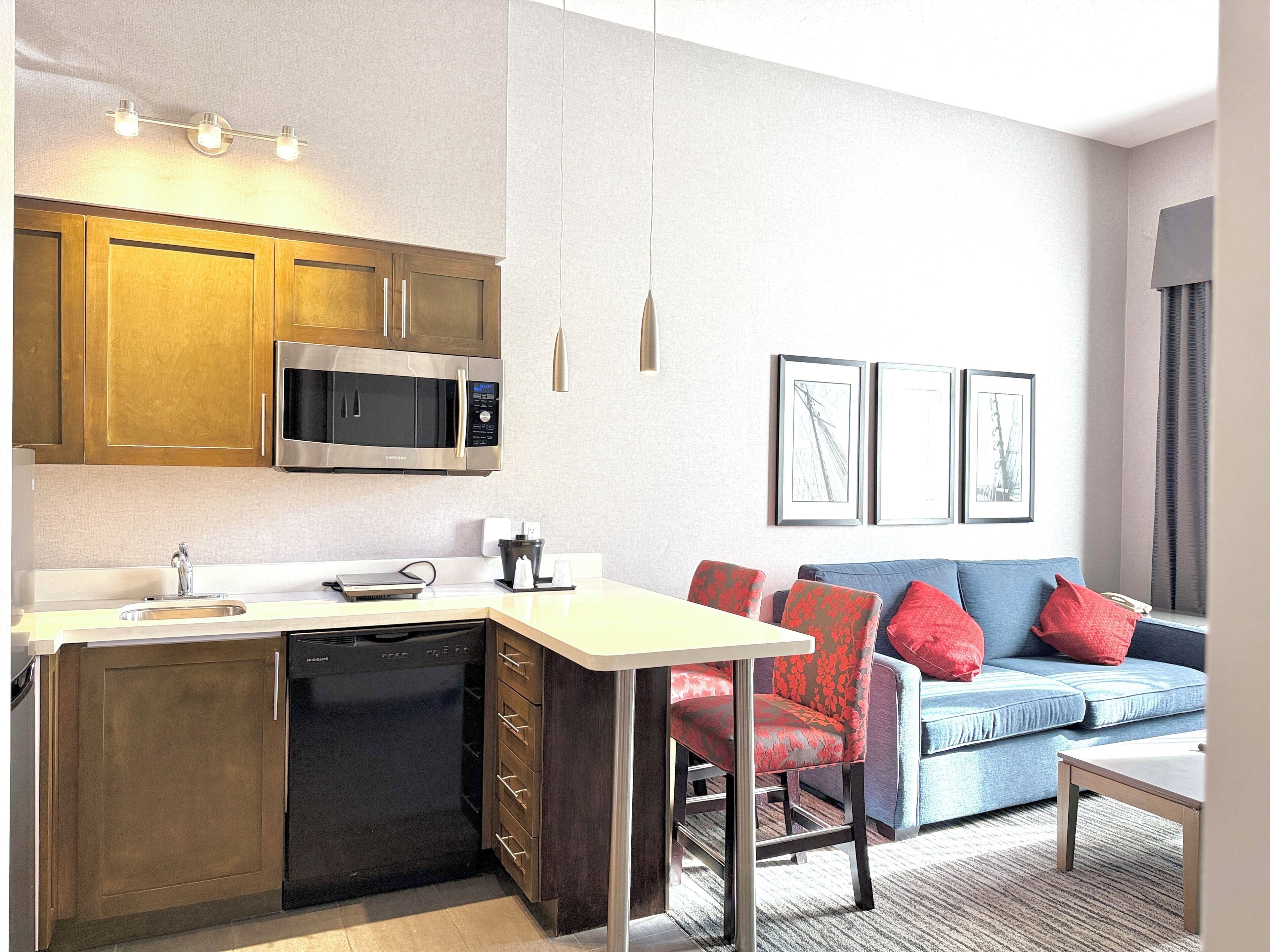 A modern kitchen with a microwave, dishwasher, and a dining area with a table and chairs.