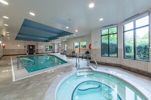 Una piscina techada, sillones reclinables de piscina