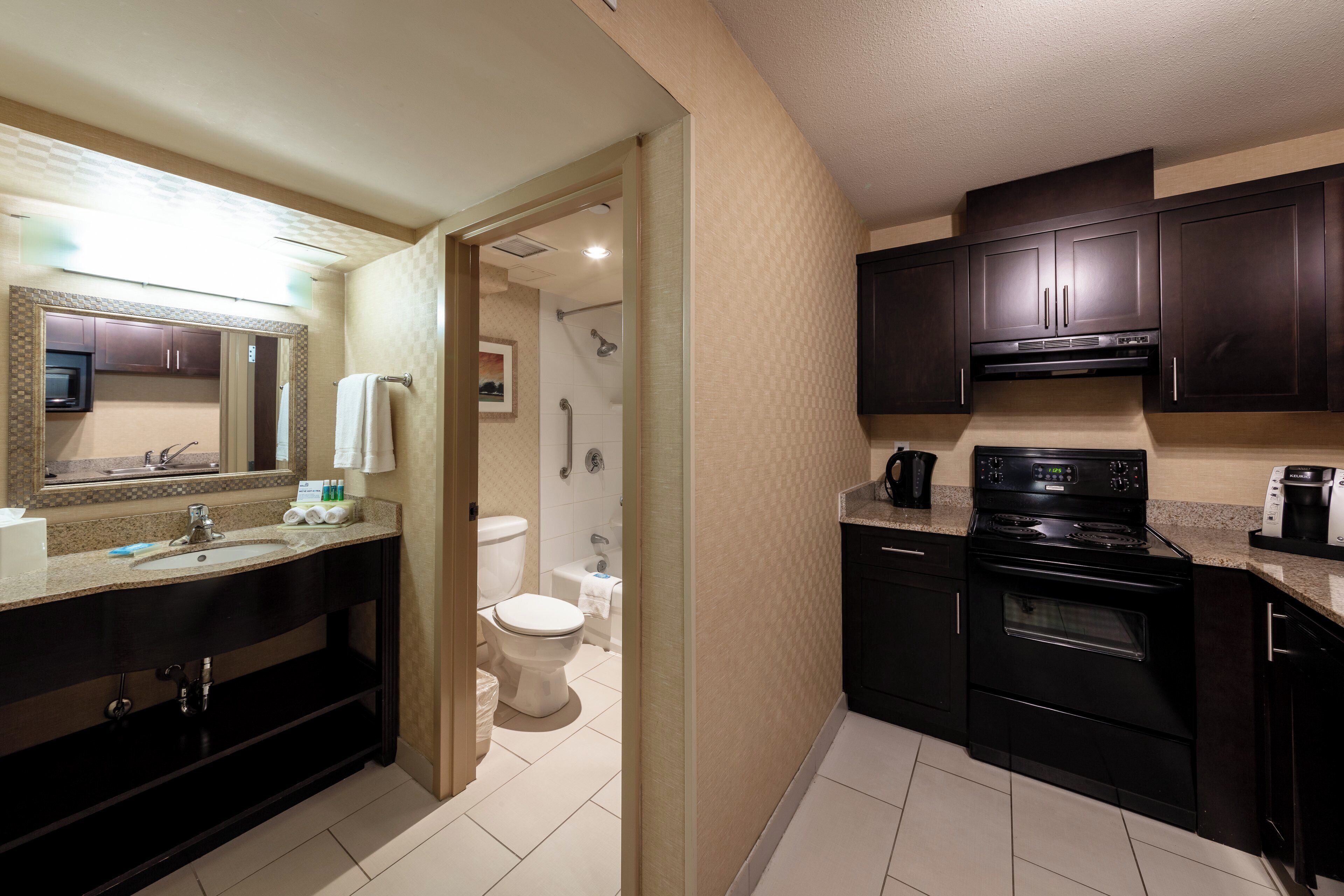 A modern bathroom with a sink, mirror, and toilet.