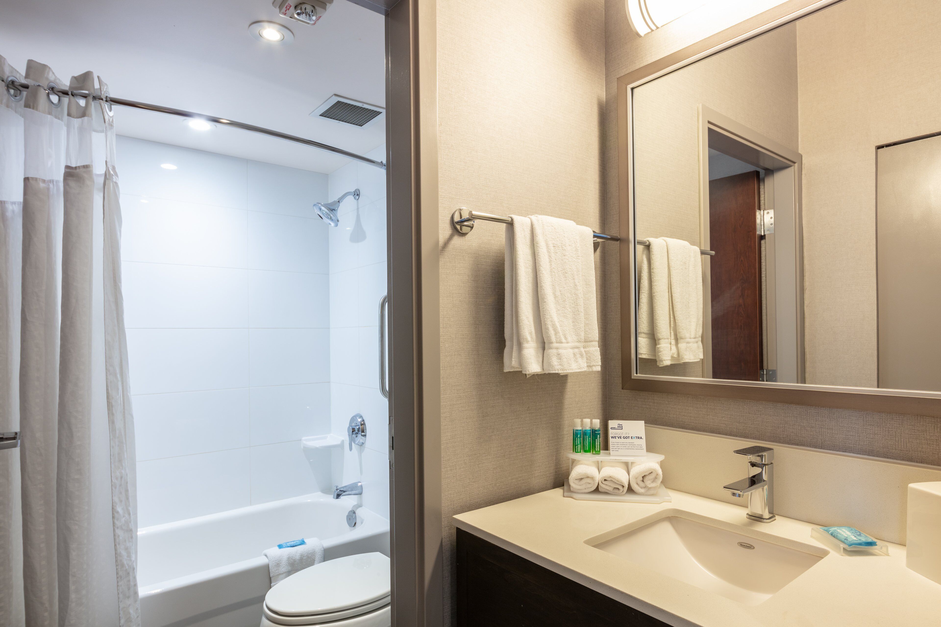 A modern bathroom with a bathtub, toilet, and sink.