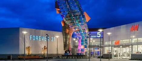 A modern building with a large illuminated sculpture in front.