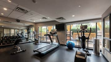 A gym with treadmills, exercise balls, and weights.