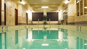 A large indoor swimming pool with clear water, marked depth lines, and a central plant. - Holiday Inn Hotel & Suites West Edmonton by IHG (Edmonton)