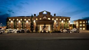 A large, multi-story hotel with a prominent entrance and a sign reading "Days Inn & Suites." - Days Inn & Suites by Wyndham Strathmore (Strathmore)