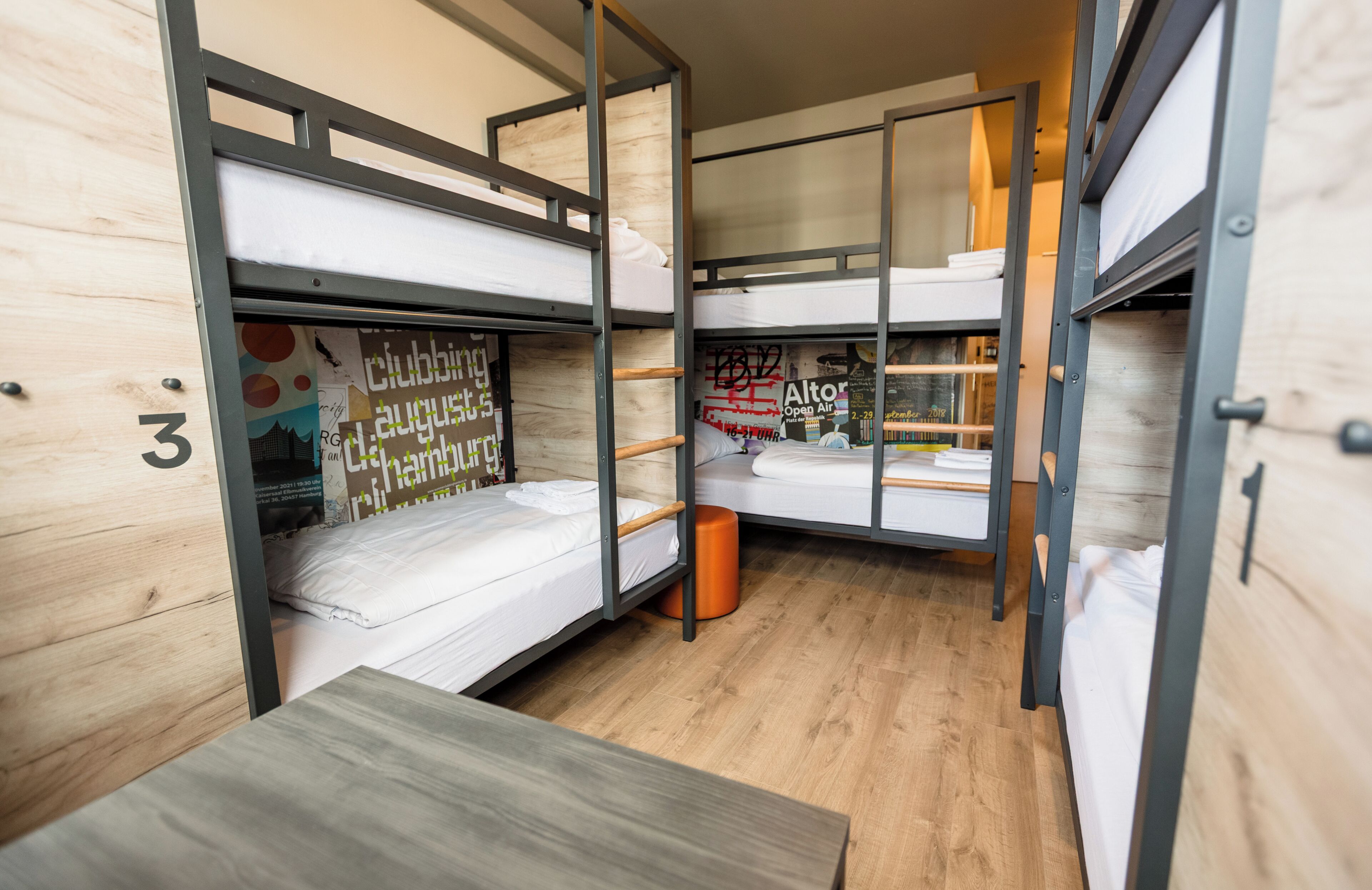 Een slaapkamer met stapelbedden, houten wanden en een klein tafeltje.
