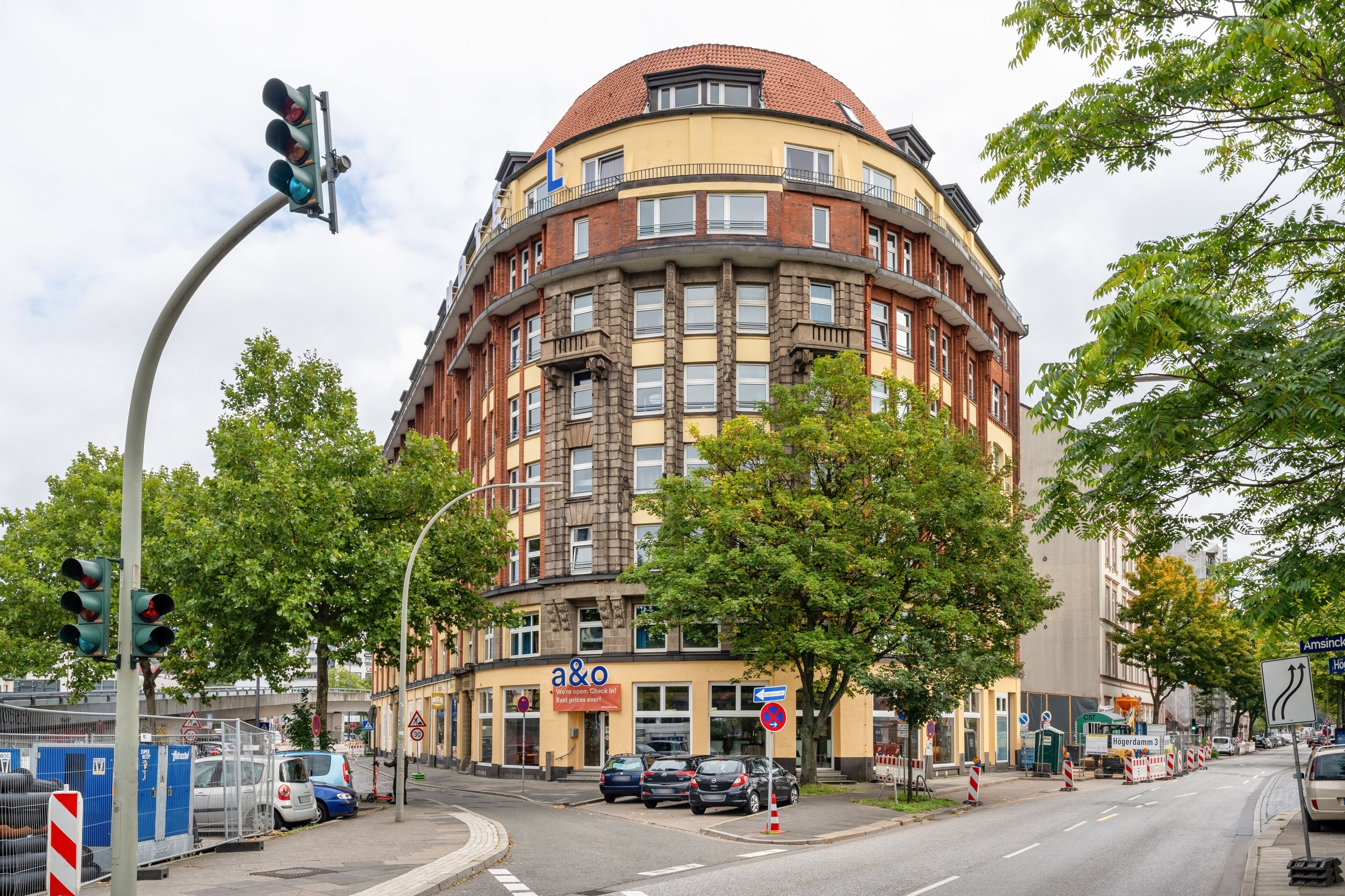 A multi-story building with a rounded corner, featuring a prominent 'a&o' sign on the ground floor.