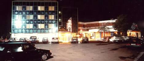 Ein Parkplatz mit mehreren Autos und einem Gebäude mit einer rasterförmigen Fassade.