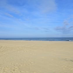 En la playa, playa de arena blanca, camastros y sombrillas