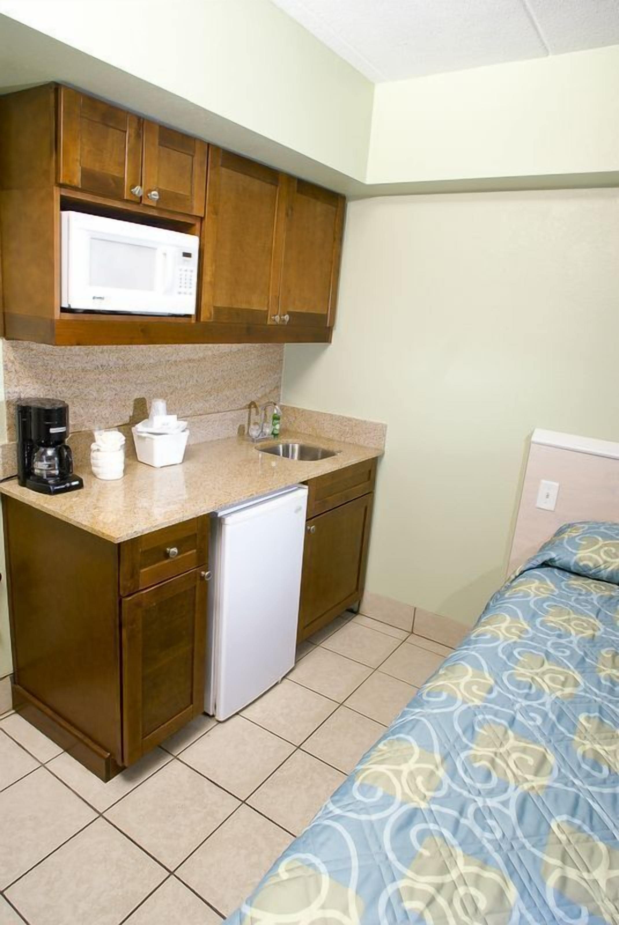 A compact kitchenette with a microwave, coffee maker, and a small refrigerator.
