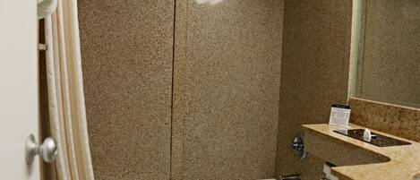 A bathroom with a bathtub, a shower, and a sink with a granite countertop.
